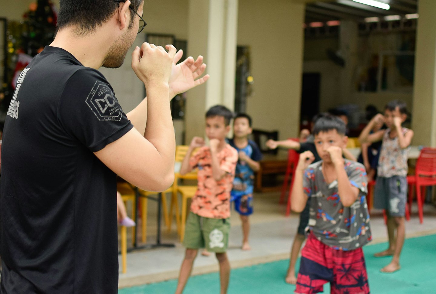 Instructor demonstrates martial arts hand positions to young boys.