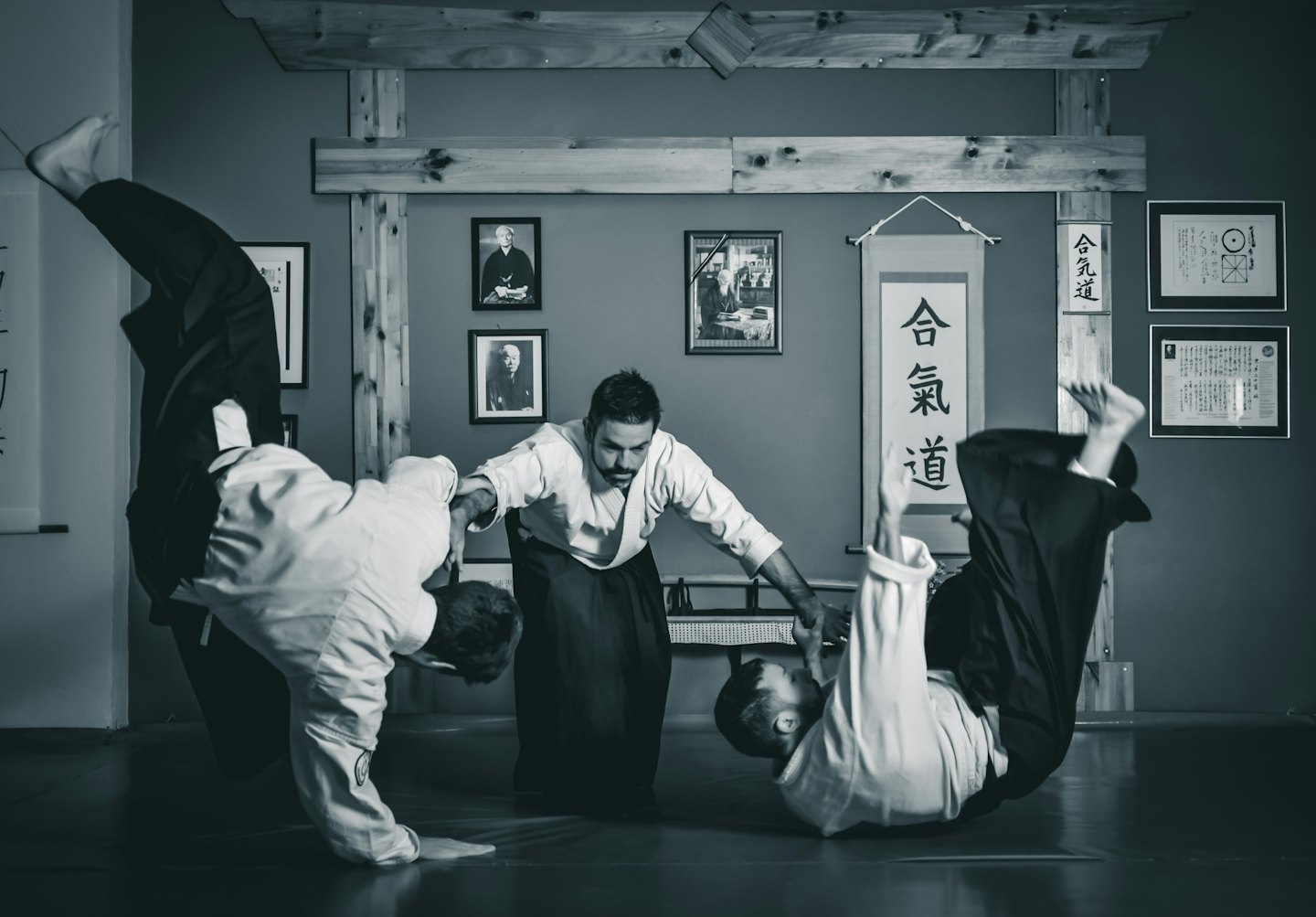 Aikido instructor teaching students martial arts in a dojo.