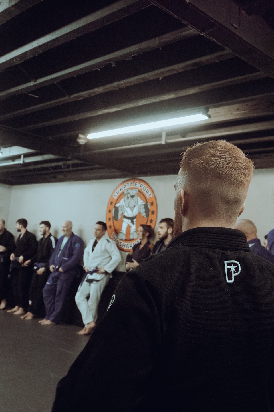 Martial arts students standing in line inside a dojo.